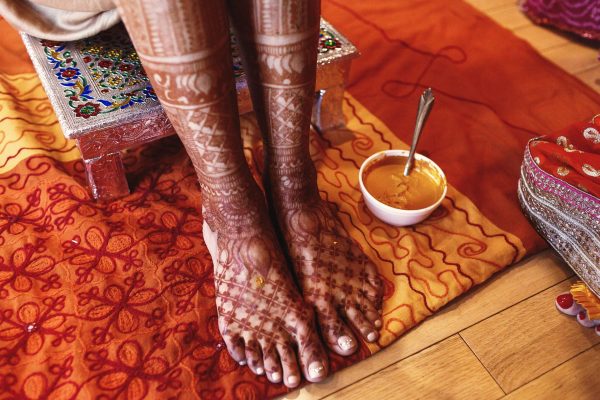 white-bowl-with-turmeric-paste-stands-beneath-indian-bride-min
